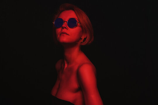 Portrait of fashion real young girl in red neon light in the studio