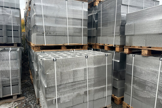 Stacked and wrapped pallets of concrete blocks outdoors