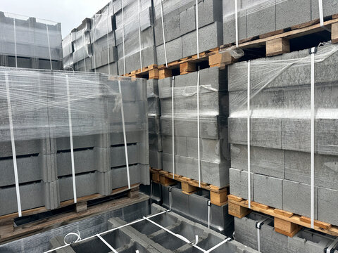 Stacked and wrapped concrete block pallets in storage