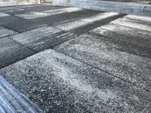 Close-up surface of dark grey concrete paving slabs outdoors