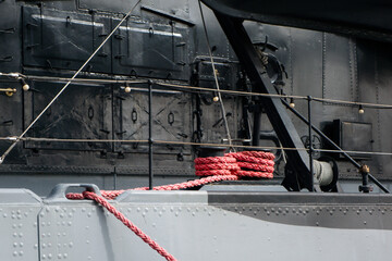 GDYNIA, POLAND - SEPTEMBER 19, 2026: Detailed view of a thick red mooring rope wrapped around a bitt on the camouflaged deck of the historic warship ORP Blyskawica © MarijaBazarova