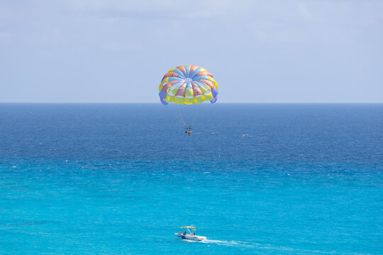Colorful Parasail Towed by Boat Over Turquoise Caribbean Sea in Cancun