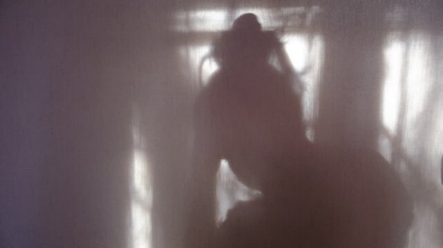 Shadow of a woman captured in a pose of despair and anxiety, emotional distress and the silent struggle with mental health. Deep vulnerability, overwhelming sadness, inner turmoil, need for support.
