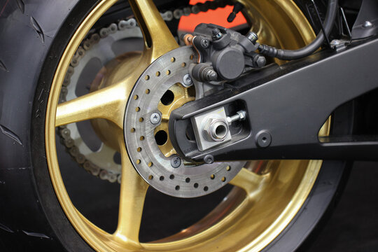 Rear motorcycle wheel with gold rim and brake disc