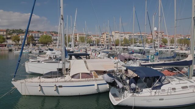 Rows of sailboats moored side by side in a crowded marina on a sunny day, Golfe-Juan, France.