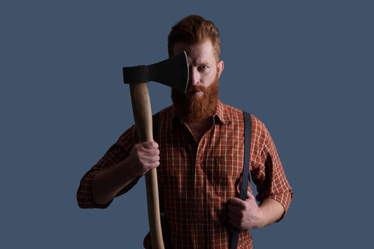 Redhead brutal man with beard and moustache. Masculine energy. Retro style. Handsome and charismatic. Masculine man. Masculinity of bearded man with axe isolated on grey