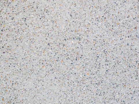 Exposed aggregate concrete texture paving, multicolor speckled gravel surface close-up background