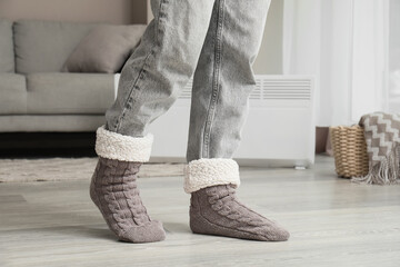 Hygge lifestyle and comfort at home, person wearing warm knitted wool socks with fleece lining for cozy winter relaxation in a modern living room © Pixel-Shot