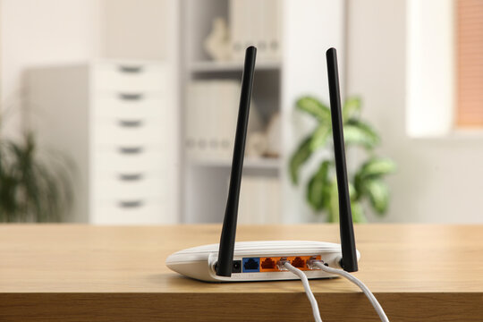 Connectivity and internet access, wireless router with ethernet cables on a wooden desk in a home office for remote work and digital communication