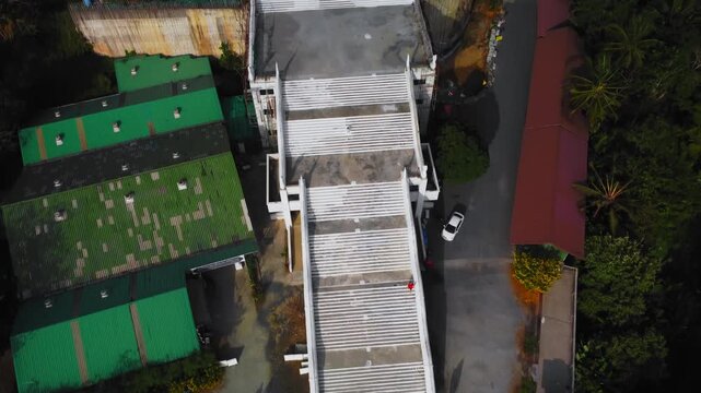 Drone shot showcasing Big Buddha stute on the ocean background. Aerial landscape of staircase leading to religious monument located on the green hill in Thailand. Spiritual and cultural content theme.