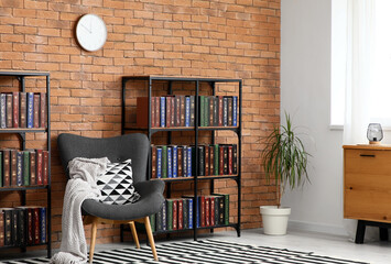Home library and reading nook, cozy interior design with armchair and bookshelves against brick wall for education, literature, and study environment © Pixel-Shot