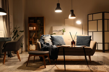 Cozy home interior with warm lighting, relaxation and comfort concept, modern living room with sofa and soft decor for peaceful evening atmosphere © Pixel-Shot