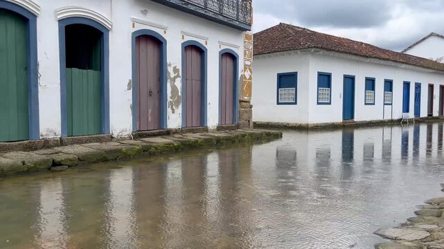 Flooded cobblestone street with reflection in colonial historic town during light rain, empty street view, Paraty, Rio de Janeiro, Brazil