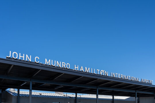 Mount Hope, Hamilton, Ontario, Canada - October 17, 2026: John C. Munro Hamilton International Airport sign above the entrance against blue sky with copy space. Mount Hope, Hamilton, Ontario, Canada. 