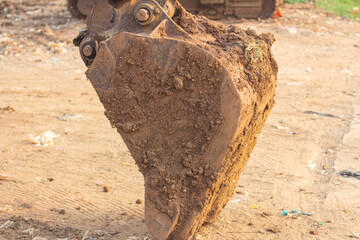 detail of thick, dried soil and cracked mud texture stuck on an iron excavator shovel bucket © edy waluyo
