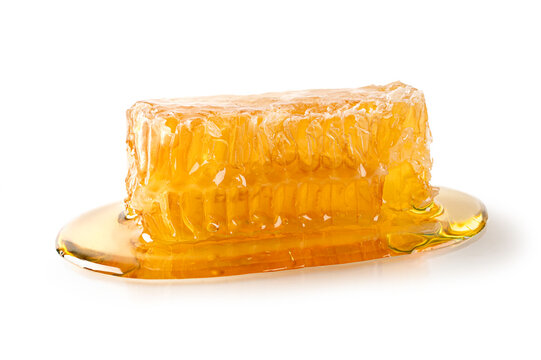 Golden Honeycomb Dripping with Pure Honey on White Background. Close up 