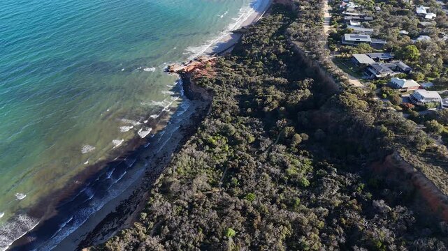 Aerial drone view of the eroding coastal cliffs of Anglesea, Victoria, Australia, residential properties sitting in close proximity to the cliff edge. Ongoing risk of coastal erosion to nearby homes