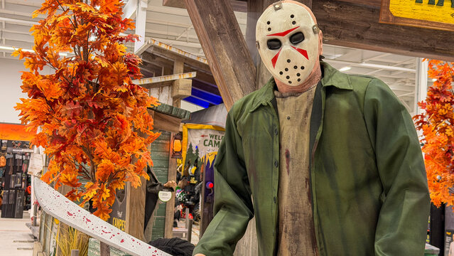 Regina, Canada - October 15, 2026: Life-size Jason Voorhees animatronic figure with hockey mask and bloody machete inside Spirit Halloween seasonal store display