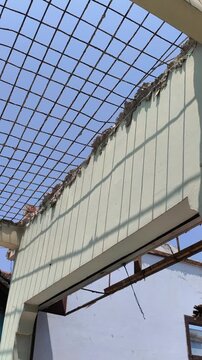 Severely damaged or collapsed building ceiling with exposed steel frames, illustrating destruction after incidents such as a gas cylinder explosion or earthquake.
