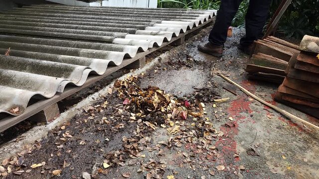 Gathering Rooftop Waste into Pile with Broom