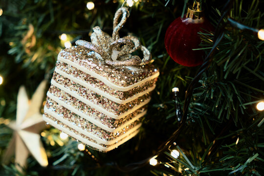 Glittering Christmas Gift Ornament Hangs on Festive Tree