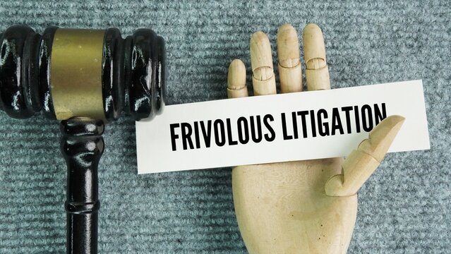 Penukul hakim and paper with the word frivolous lawsuit or frivolous litigation is a legal claim, motion, or appeal filed with little to no regard for whether it has any foundation in fact or existing