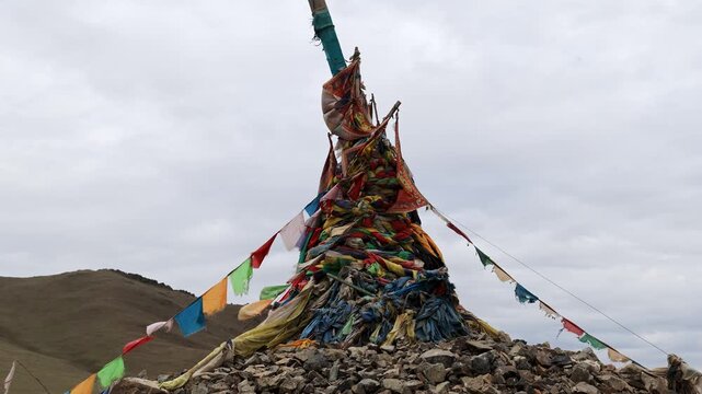 Colorful Flags Fluttering on Wind Above Ovoo Stones in Mongolian Steppe