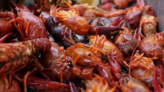 Freshly cooked red crawfish pile on a metal tray