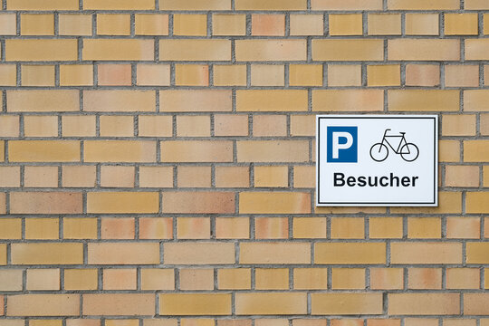 Hinweisschild f&uuml;r Parkpl&auml;tze f&uuml;r Fahrr&auml;der von Besuchern an der Hauswand einer Beh&ouml;rde in Deutschland