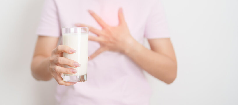 Lactose intolerance and Milk allergy concept. woman with Milk glass and having abdominal cramps and pain when drink Cow Milk. Symptom stomach ache, Dairy intolerant, Nausea, Bloating, Gas and Diarrhea