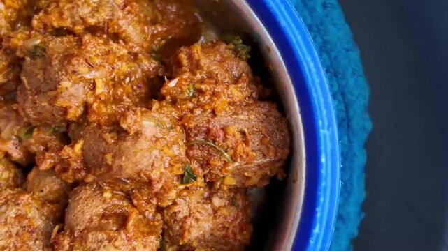 Slow camera pan right to left revealing spicy soya chunks curry in bowl