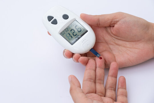 Woman's hands checking diabetes and hyperglycemia with digital blood sugar meter. Healthcare and medical concep
