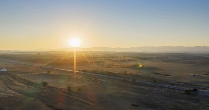 Aerial time-lapse of sun rising over autumn grassland with straight highway, Dada Line, Hexigten Geopark,Chifeng city, Inner Mongolia, China
