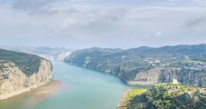 Aerial time-lapse of Yellow River bend with cliffs, ancient watchtower at Laoniuwan village, Pianguan county, Shanxi province, China
