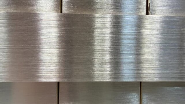 Brushed stainless steel panel with linear grain, textured metal surface detail