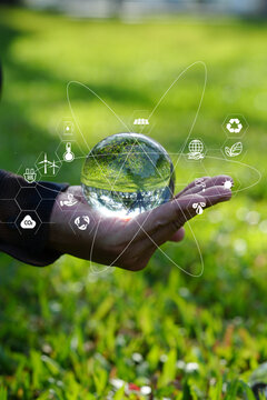 Hand Cupping Glass Globe with Green Technology and Environmental Protection Icons