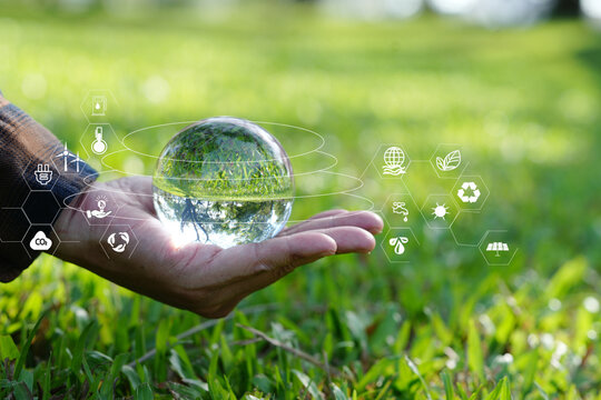Hand Cupping Glass Globe with Green Technology and Environmental Protection Icons