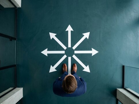 Decisionmaking Businessman Standing at Crossroads of Multiple Directional Options