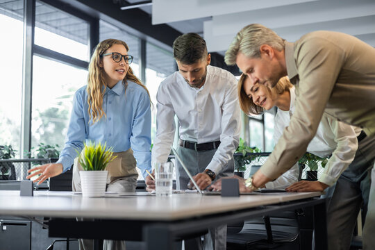 Startup business team on meeting in modern bright office interior and working on laptop