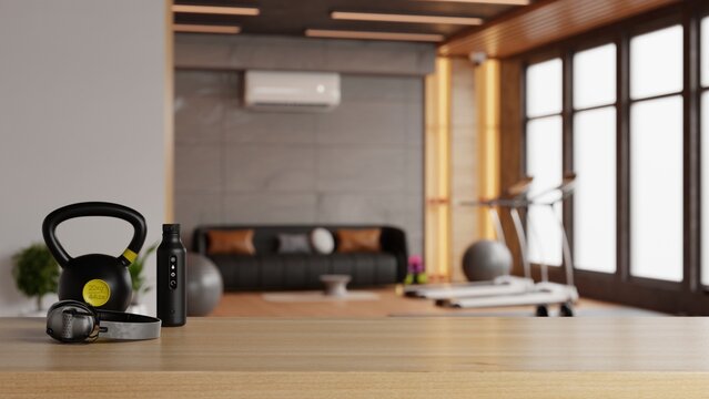 Wooden table top product display with kettlebell bottle and headphones over blurred modern home gym room background- 3D rendering