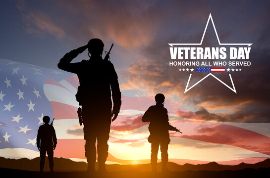 Silhouettes of a soldiers with USA flag against the sunset. Veterans Day concept