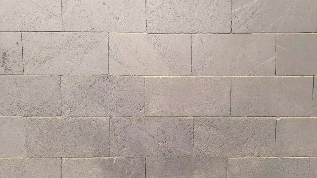 Close up view of grey volcanic stone brick wall pattern, durable natural stone cladding material for exterior building design