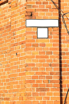blank street name frame on old red brick house's wall