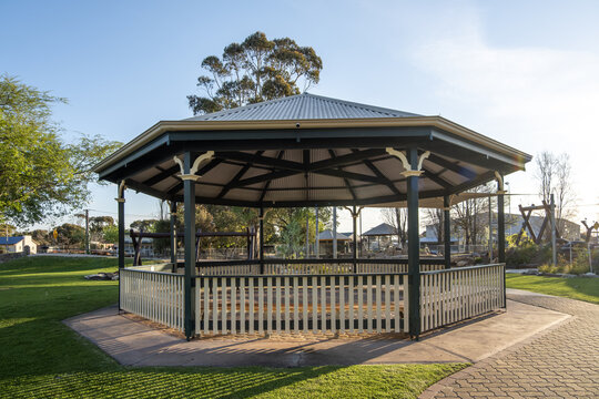 A classic and traditional rotunda with a corrugated metal roof and decorative brackets stands in a manicured public park in Keith, South Australia. Heritage character in an Australian community space