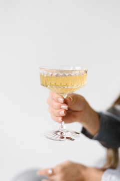 Sparkling Wine In Vintage Glass Against Plain White Backdrop