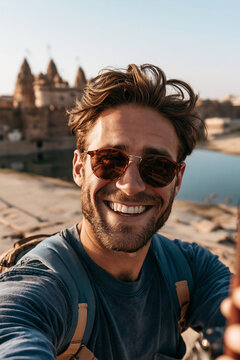 Selfie in Asia smiling young traveler exploring historic Indian temple complex beside peaceful lake during memorable cultural vacation adventure