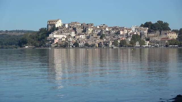 Scenic italian village of anguillara sabazia reflecting on lake bracciano