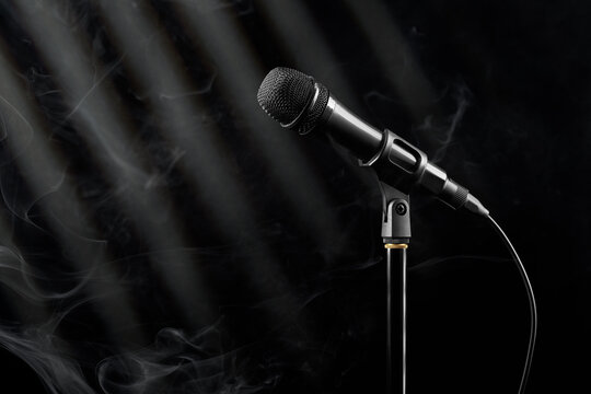 Microphone on stand under spotlight with smoke