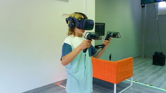 Child wearing vr headset playing virtual reality game indoors