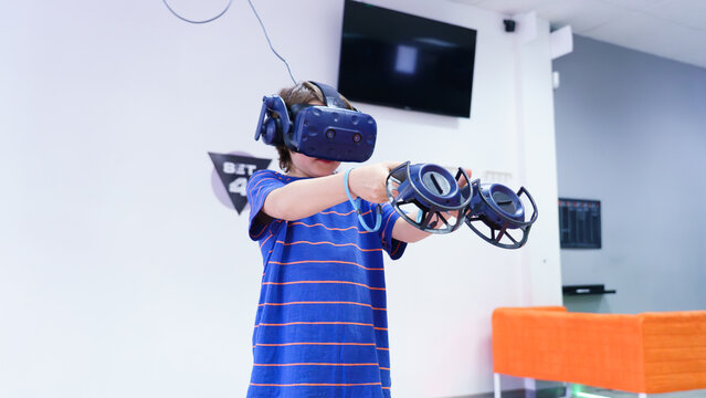 Boy playing virtual reality game with controller headset